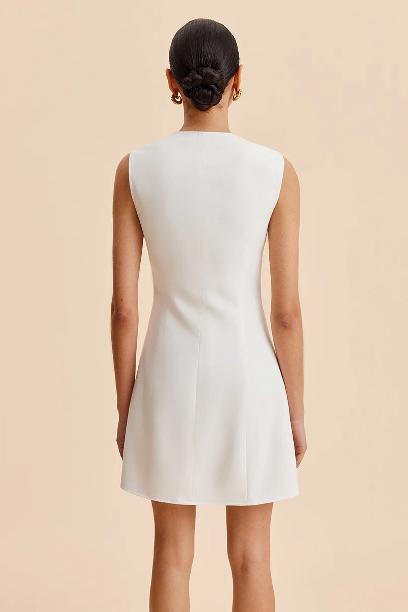 White - Women's white sleeveless tailored mini dress featuring an asymmetrical wavy front placket and large ornate statement buttons.