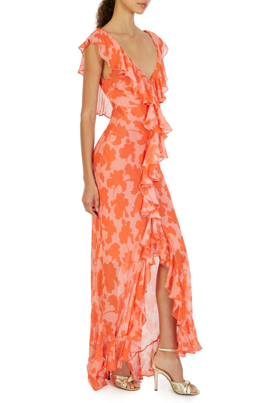 Orange - A woman models an elegant, flowing maxi dress featuring a bold floral print, plunging V-neckline, cascading ruffle details down the front, and a high thigh slit.