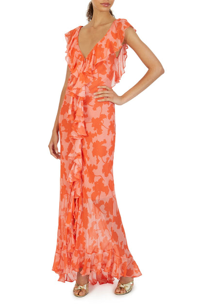 Orange - A woman models an elegant, flowing maxi dress featuring a bold floral print, plunging V-neckline, cascading ruffle details down the front, and a high thigh slit.