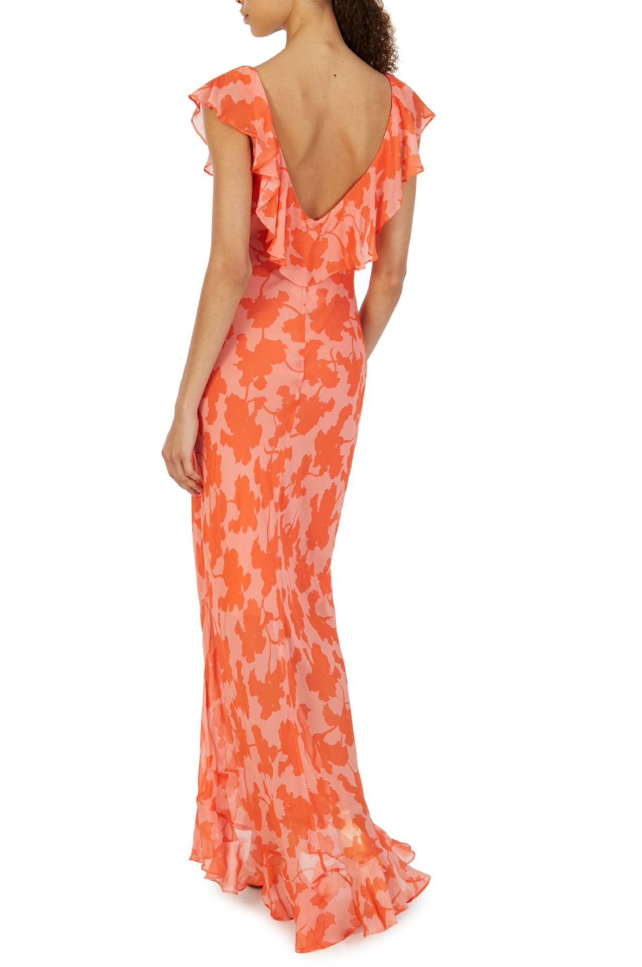Orange - A woman models an elegant, flowing maxi dress featuring a bold floral print, plunging V-neckline, cascading ruffle details down the front, and a high thigh slit.