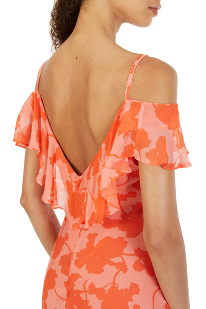 Orange - A woman models an elegant, flowing maxi dress featuring a bold floral print, plunging V-neckline, cascading ruffle details down the front, and a high thigh slit.