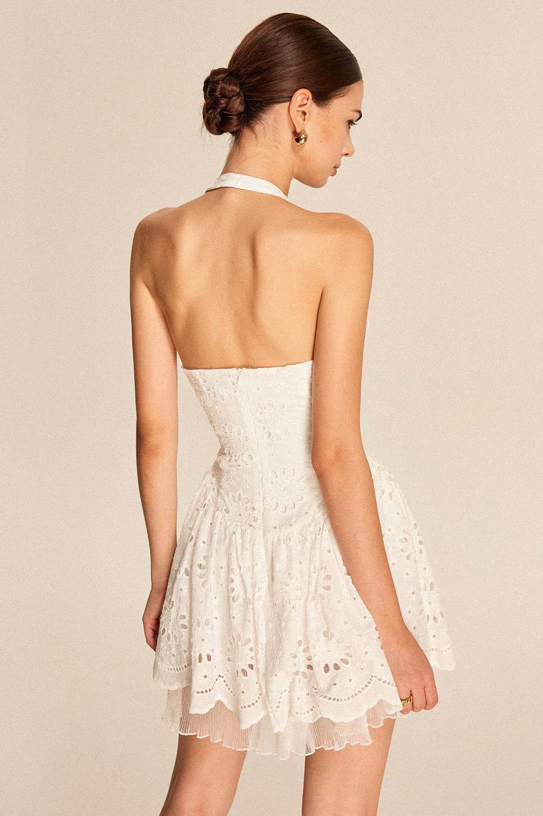White - Women's white halter mini dress featuring all-over broderie anglaise, a plunging neckline, button front detailing, and a flared scalloped hem with a sheer underlayer.