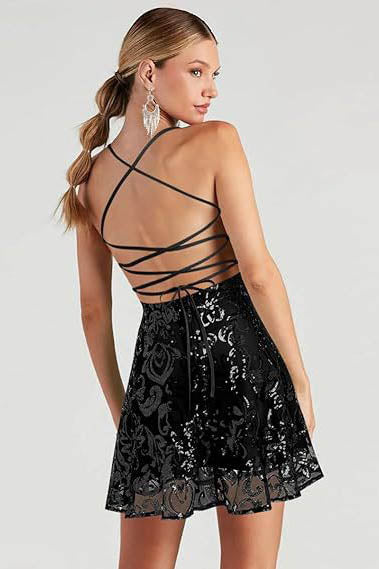 Full-length view of a model wearing a black A-line mini dress with spaghetti straps and a square neckline, featuring an all-over black sequin baroque pattern.