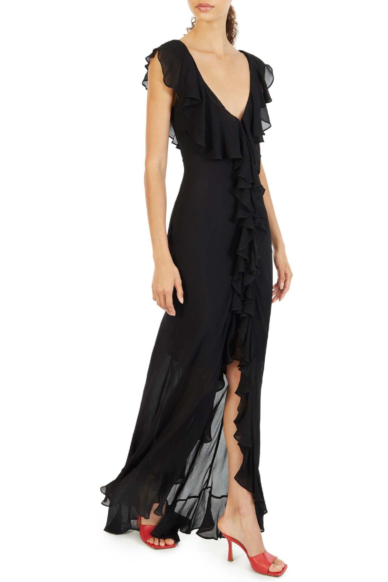 Black - A woman models an elegant, flowing maxi dress featuring a bold floral print, plunging V-neckline, cascading ruffle details down the front, and a high thigh slit.