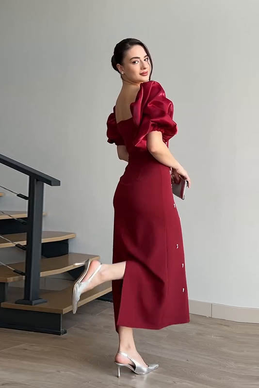 Red - A woman wearing an elegant deep red midi dress featuring large, shiny puff sleeves, a square neckline, and scattered pearl-like embellishments, paired with silver heels and a matching clutch.