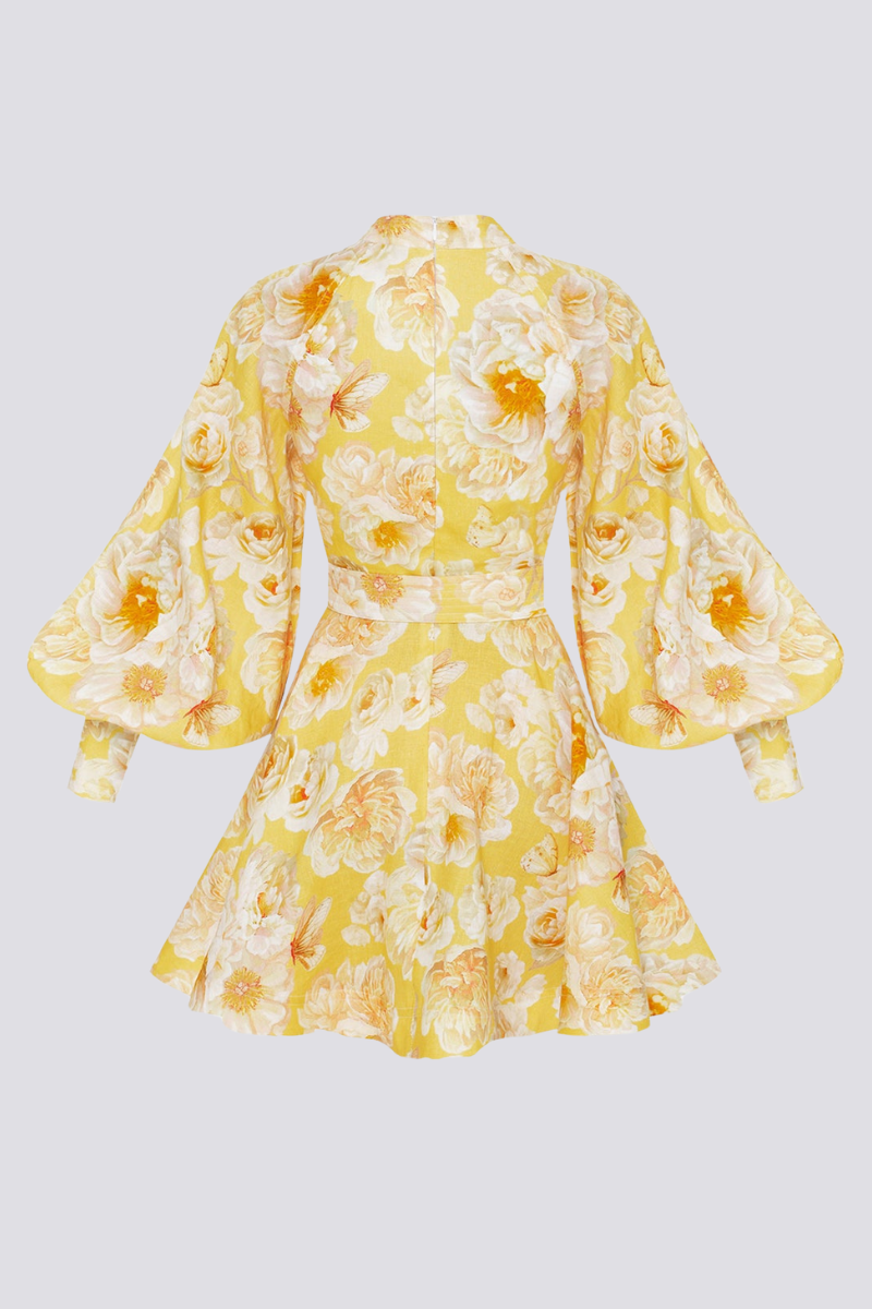Yellow - A woman wearing a yellow mini dress with a large white floral print, featuring long balloon sleeves, a high neckline with button detailing, and a waist tie belt.