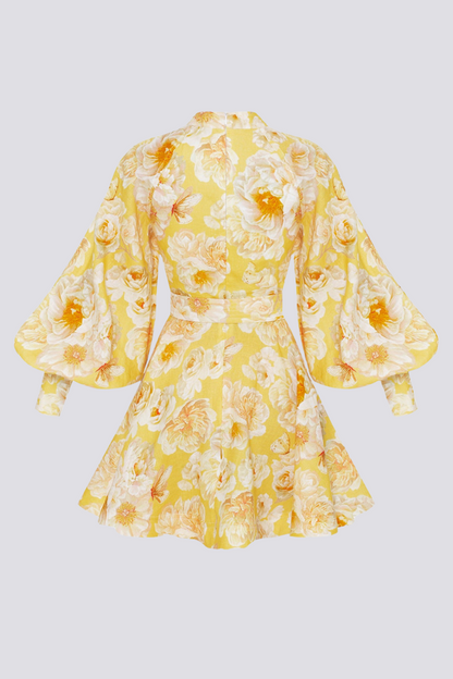 Yellow - A woman wearing a yellow mini dress with a large white floral print, featuring long balloon sleeves, a high neckline with button detailing, and a waist tie belt.