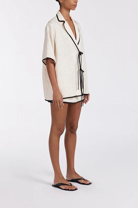 Women's relaxed fit short-sleeve shirt featuring a notched lapel collar, double tie-front fastening, and dark contrast piping.