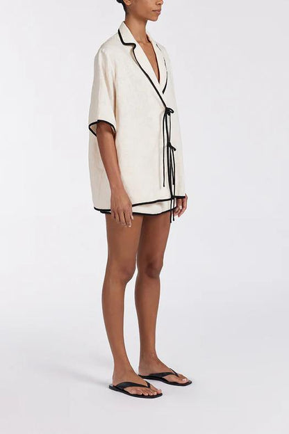 Women's relaxed fit short-sleeve shirt featuring a notched lapel collar, double tie-front fastening, and dark contrast piping.