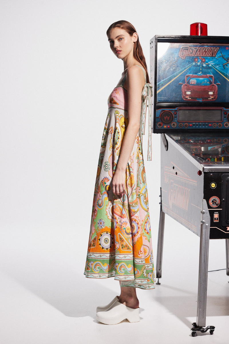 Multicolor - A woman wearing a colourful, sleeveless midi dress with a square neckline, empire waist, and an intricate psychedelic bohemian placement print.