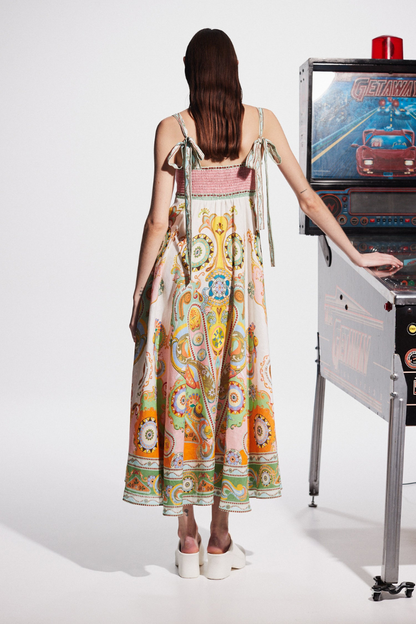Multicolor - A woman wearing a colourful, sleeveless midi dress with a square neckline, empire waist, and an intricate psychedelic bohemian placement print.