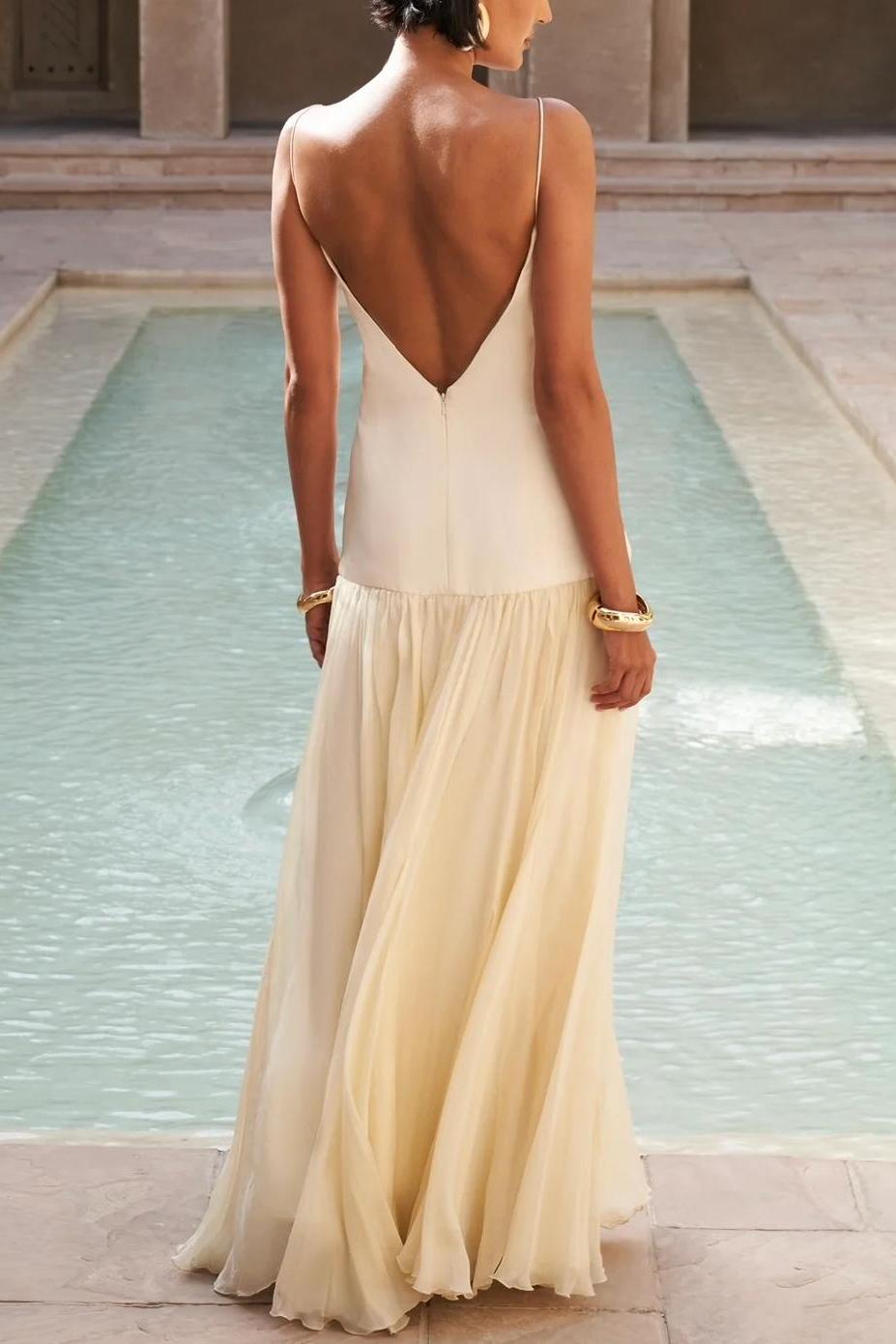 Butter Yellow - A woman wearing an elegant drop-waist maxi dress featuring a white V-neck slip bodice and a flowing, semi-sheer cream gathered skirt, styled with a matching neck scarf.