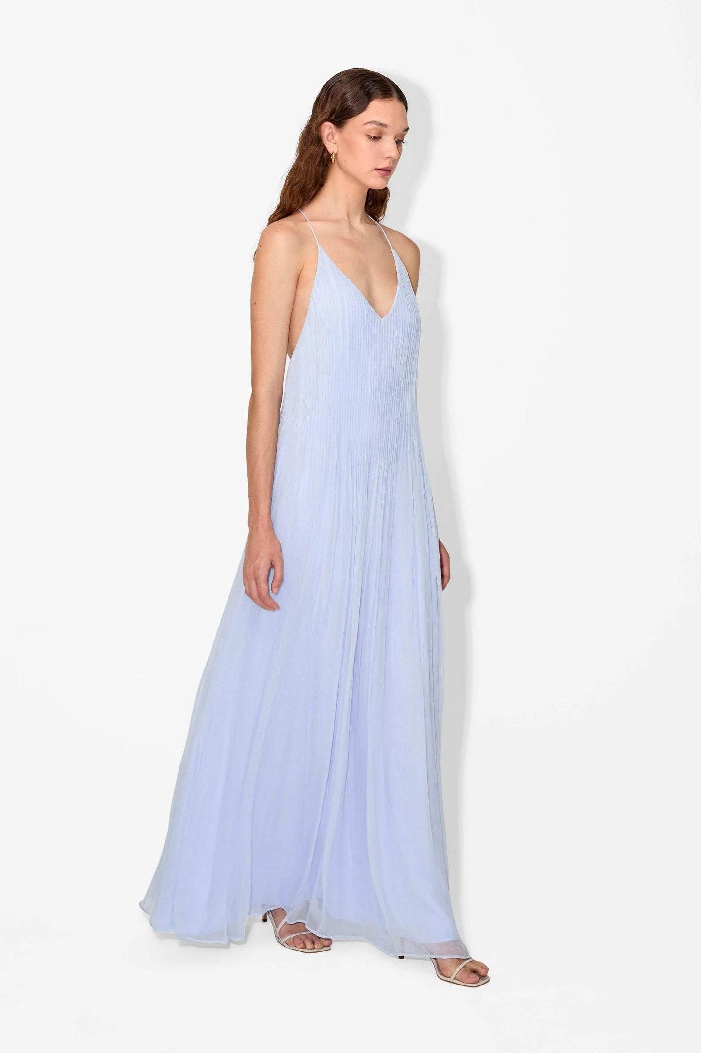 Hydrangea - Front view of a woman modelling a light blue, floor-length pleated maxi dress featuring a V-neckline and thin straps.