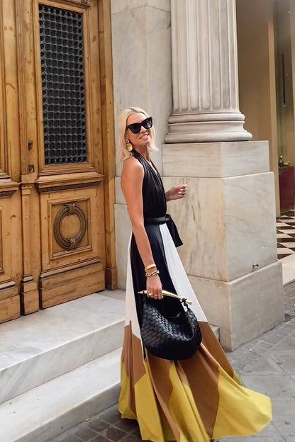 Multi - Women wearing an elegant halter neck maxi dress featuring a plunging neckline, wide tie-waist belt, and a flowing A-line skirt with bold black, white, brown, and mustard colour-block panels.