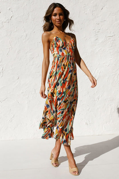 Red - A woman modelling a flowing midi dress featuring a vibrant abstract brushstroke print in yellow, green, and blue, complete with delicate straps and a ruffled hemline.