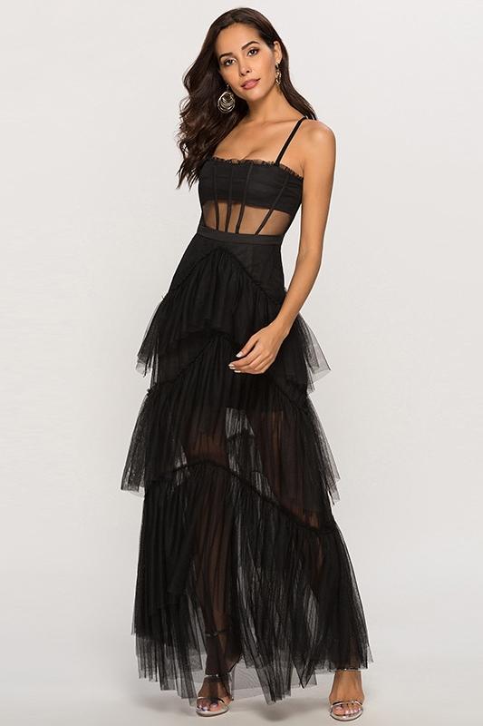Black - A woman wearing a pale pink, floor-length maxi dress featuring a structured corset-style bodice with sheer panels and a voluminous, multi-tiered tulle skirt.