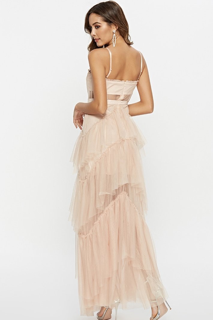 Black - A woman wearing a pale pink, floor-length maxi dress featuring a structured corset-style bodice with sheer panels and a voluminous, multi-tiered tulle skirt.