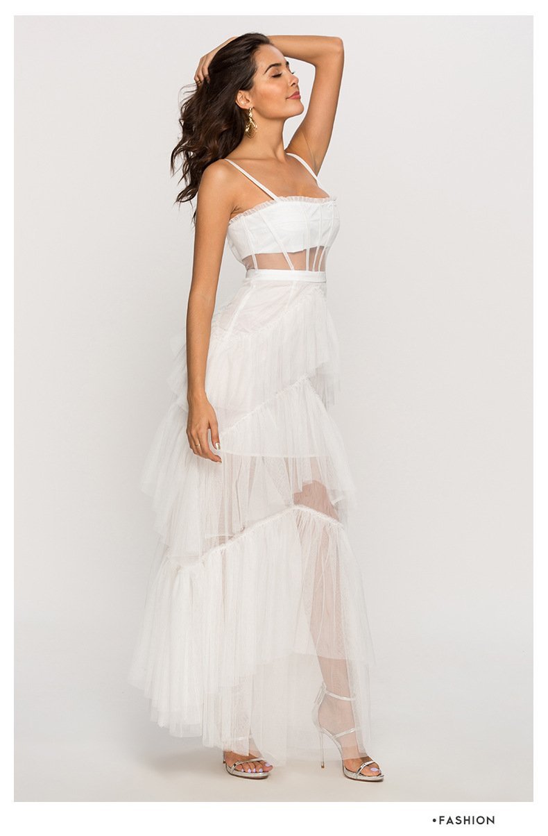 Black - A woman wearing a pale pink, floor-length maxi dress featuring a structured corset-style bodice with sheer panels and a voluminous, multi-tiered tulle skirt.