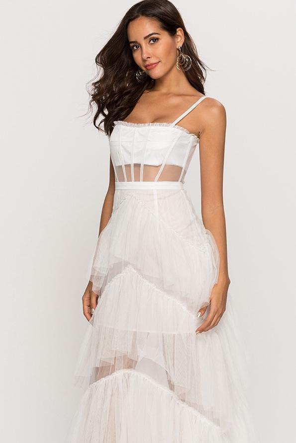 Black - A woman wearing a pale pink, floor-length maxi dress featuring a structured corset-style bodice with sheer panels and a voluminous, multi-tiered tulle skirt.