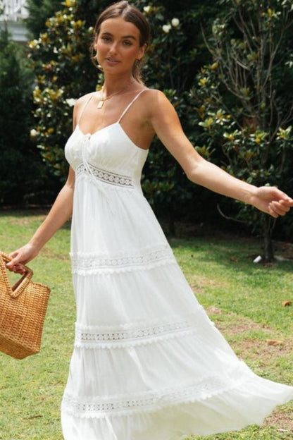 Women's white tiered maxi dress featuring spaghetti straps, a tie-front bust, and intricate crochet lace inserts along the waist and skirt.