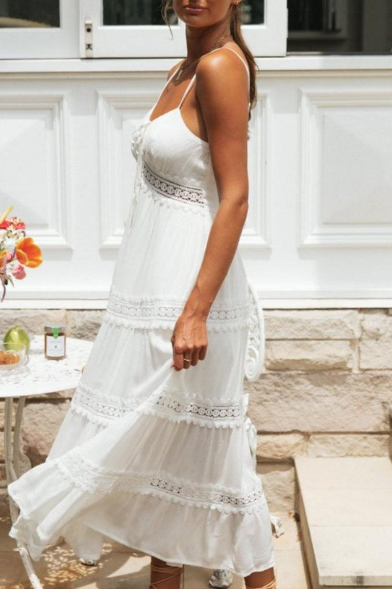 Women's white tiered maxi dress featuring spaghetti straps, a tie-front bust, and intricate crochet lace inserts along the waist and skirt.