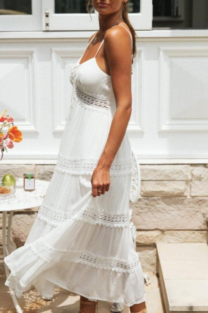 Women's white tiered maxi dress featuring spaghetti straps, a tie-front bust, and intricate crochet lace inserts along the waist and skirt.