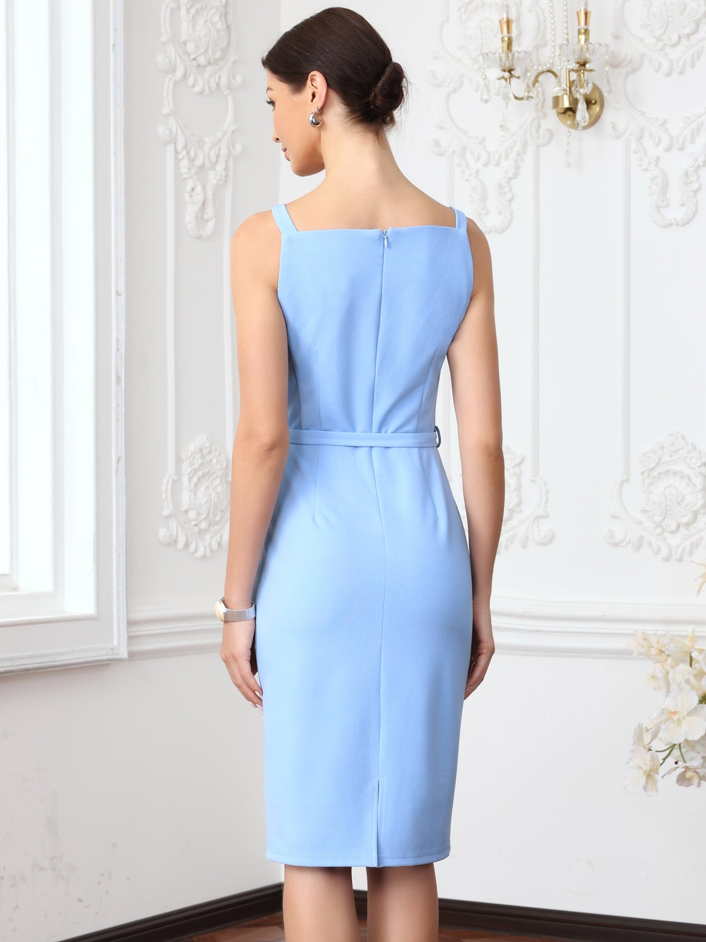 Blue - Model wearing a fitted square-neck midi dress with a matching waist belt in a structured crepe fabric, standing in an elegant room with decorative wall mouldings.