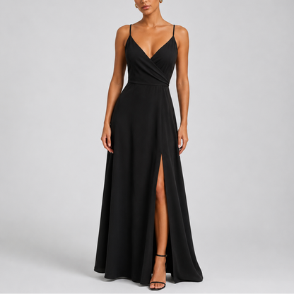 Black - Woman wearing a floor-length V-neck wrap maxi dress with delicate straps and a high side split on a plain grey background.