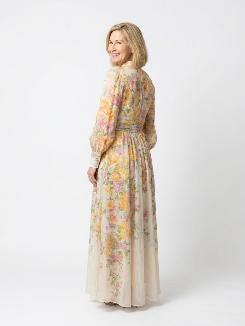 Yellow - A woman wearing a long-sleeve floral maxi shirt dress with a collared neckline and tie waist, standing against a white background.