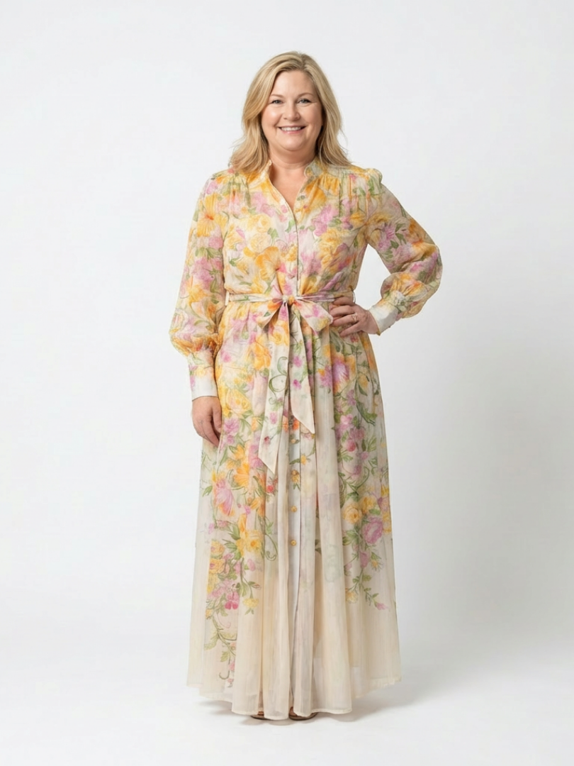 Yellow - A woman wearing a long-sleeve floral maxi shirt dress with a collared neckline and tie waist, standing against a white background.