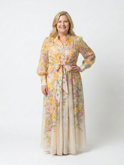 Yellow - A woman wearing a long-sleeve floral maxi shirt dress with a collared neckline and tie waist, standing against a white background.