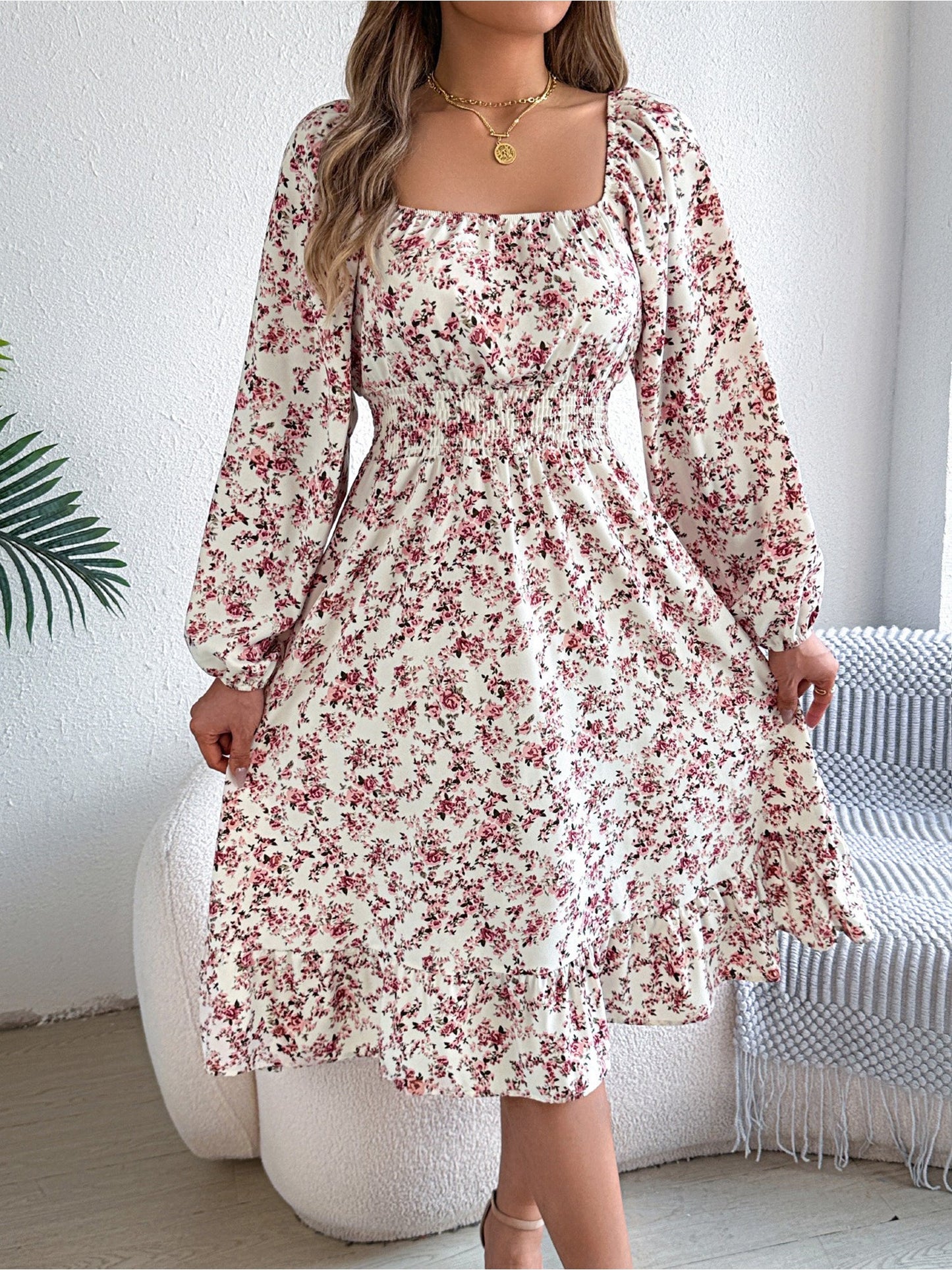 White - Woman wearing a floral square-neck midi dress with long sleeves, a shirred waist, and a ruffled hem