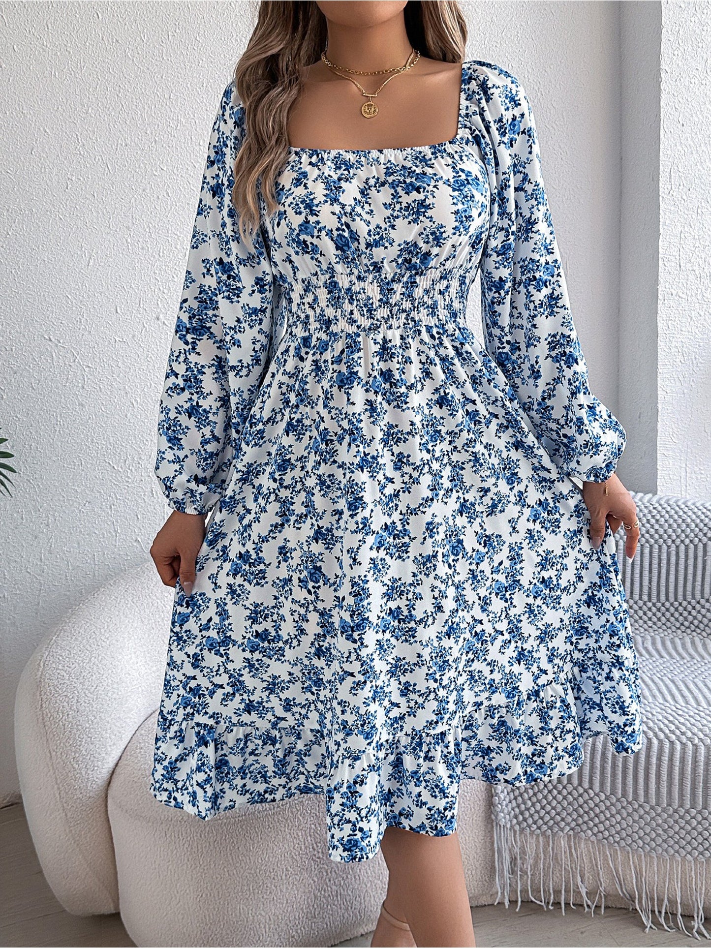 Blue - Woman wearing a floral square-neck midi dress with long sleeves, a shirred waist, and a ruffled hem