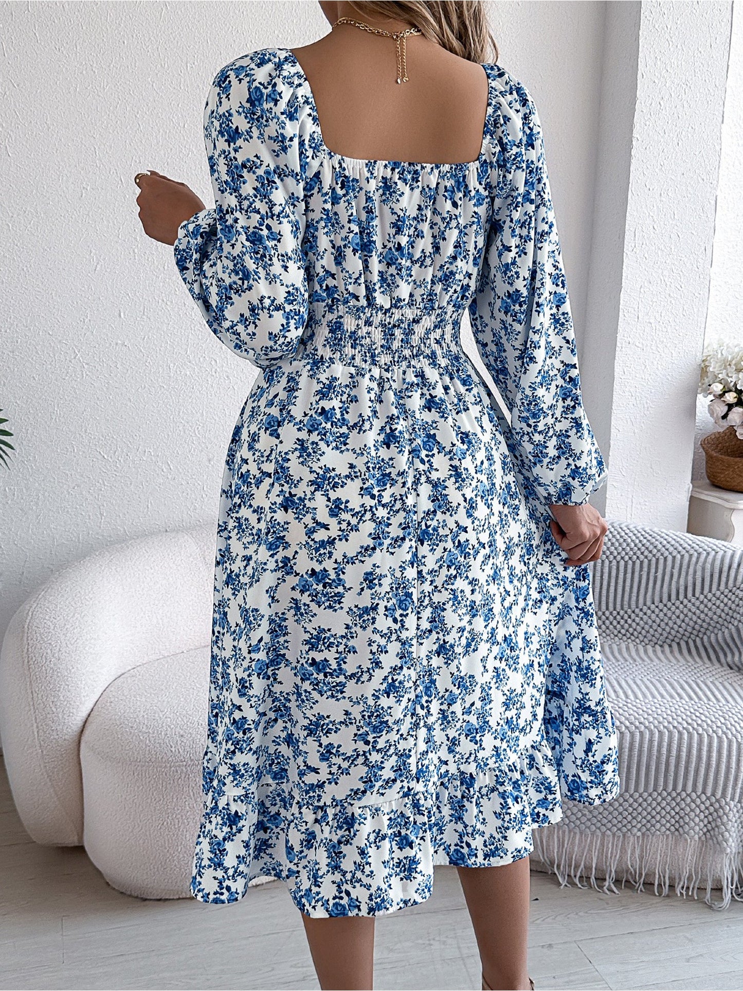 Blue - Woman wearing a floral square-neck midi dress with long sleeves, a shirred waist, and a ruffled hem