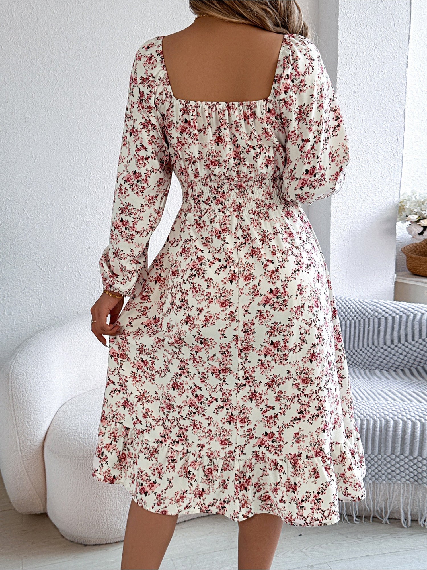 White - Woman wearing a floral square-neck midi dress with long sleeves, a shirred waist, and a ruffled hem