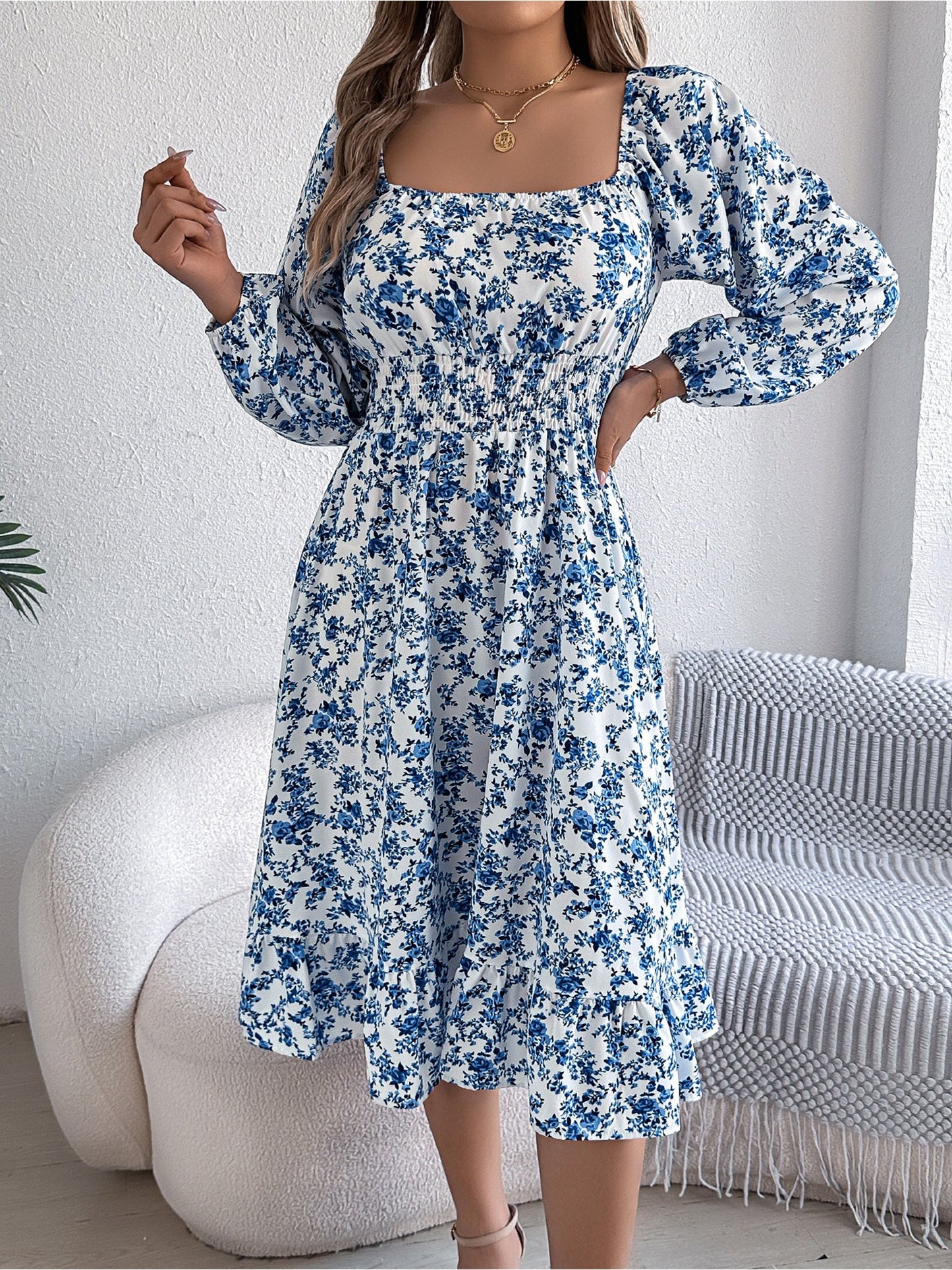 Blue - Woman wearing a floral square-neck midi dress with long sleeves, a shirred waist, and a ruffled hem