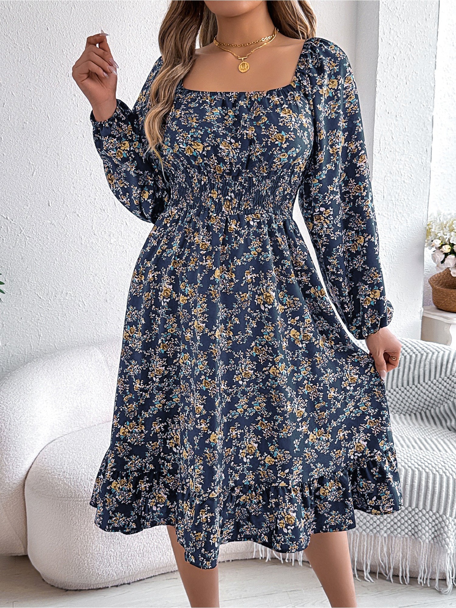 Navy - Woman wearing a floral square-neck midi dress with long sleeves, a shirred waist, and a ruffled hem