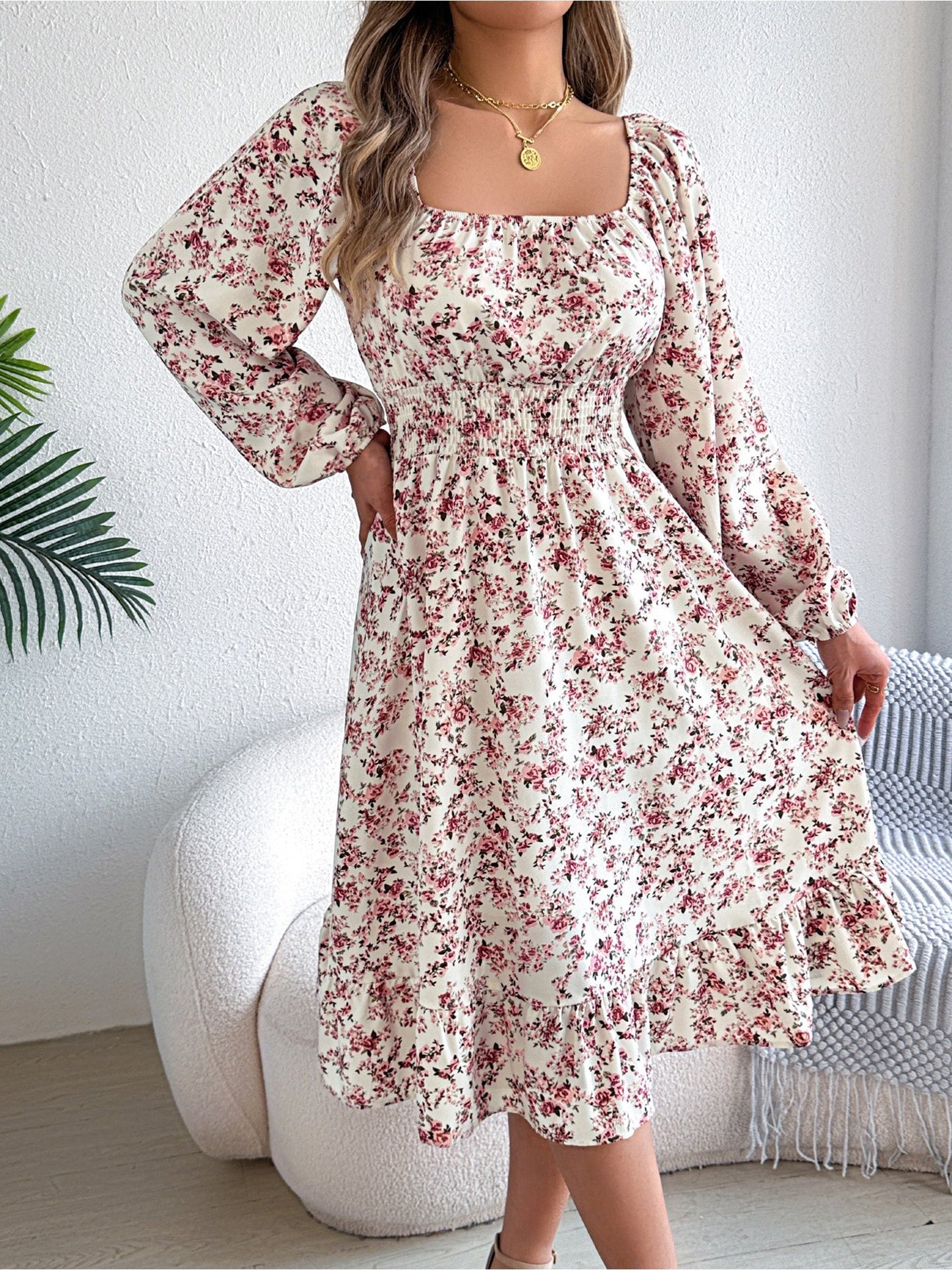 White - Woman wearing a floral square-neck midi dress with long sleeves, a shirred waist, and a ruffled hem