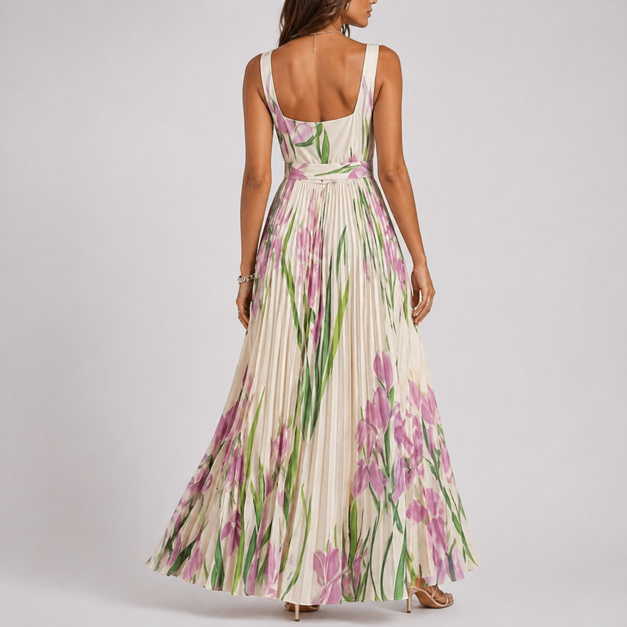 White - A woman wearing a floral pleated maxi dress with a square neckline, wide straps, and a flowing A-line skirt.