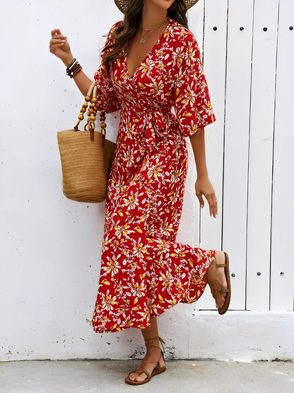 Red - Model wearing a floral V-neck wrap maxi dress with short sleeves and a waist tie, styled with a woven tote bag and sandals.