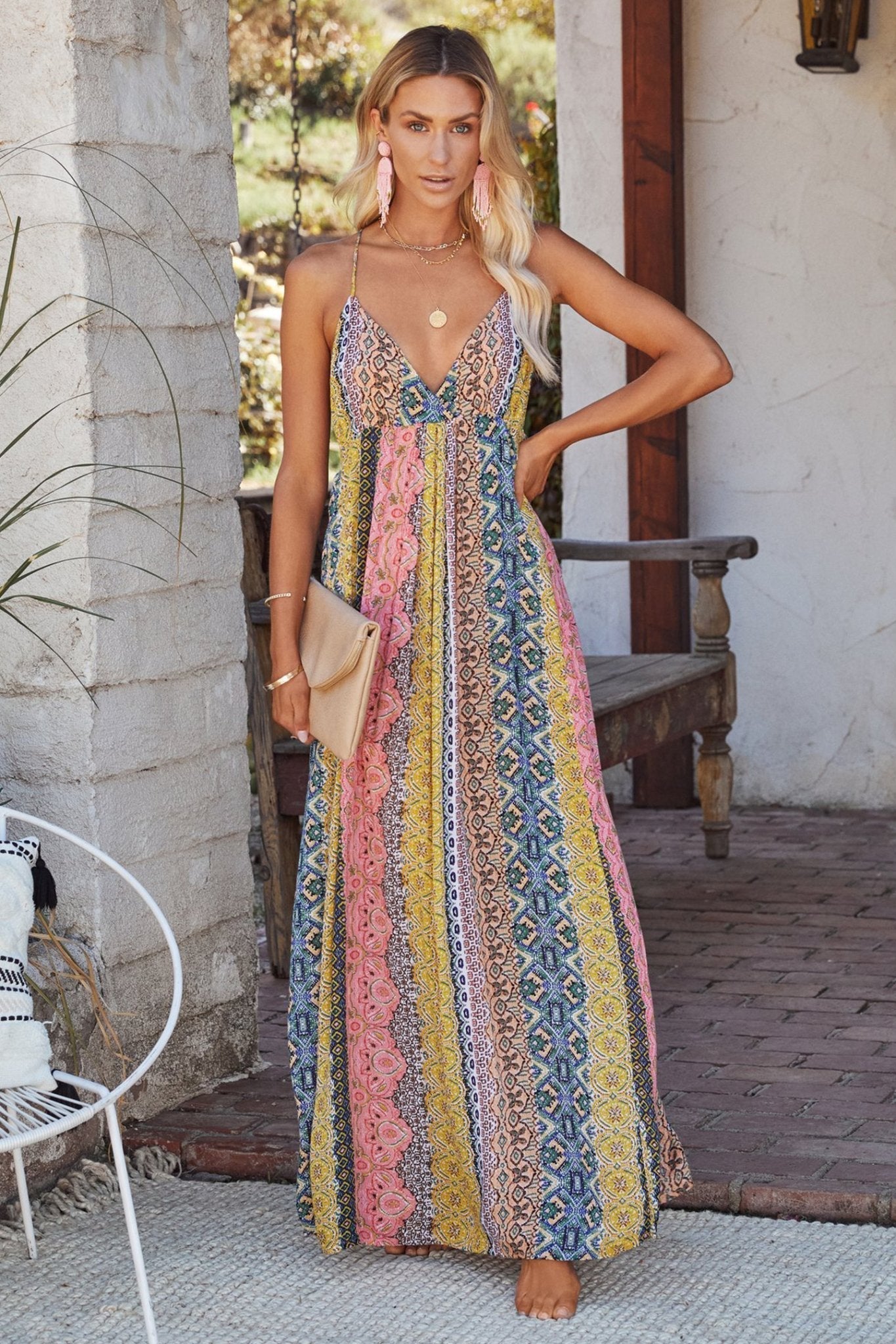 Multi - A woman models a vibrant, sleeveless maxi dress featuring a V-neckline and a detailed vertical bohemian geometric print in a relaxed, flowing fit.