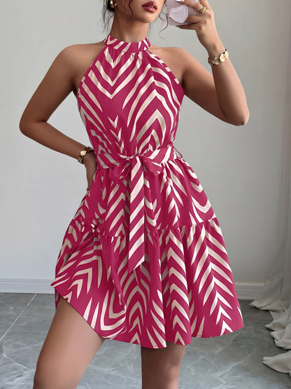 Rose Red - Woman wearing a geometric patterned halter-neck mini dress with a tie waist and tiered skirt.