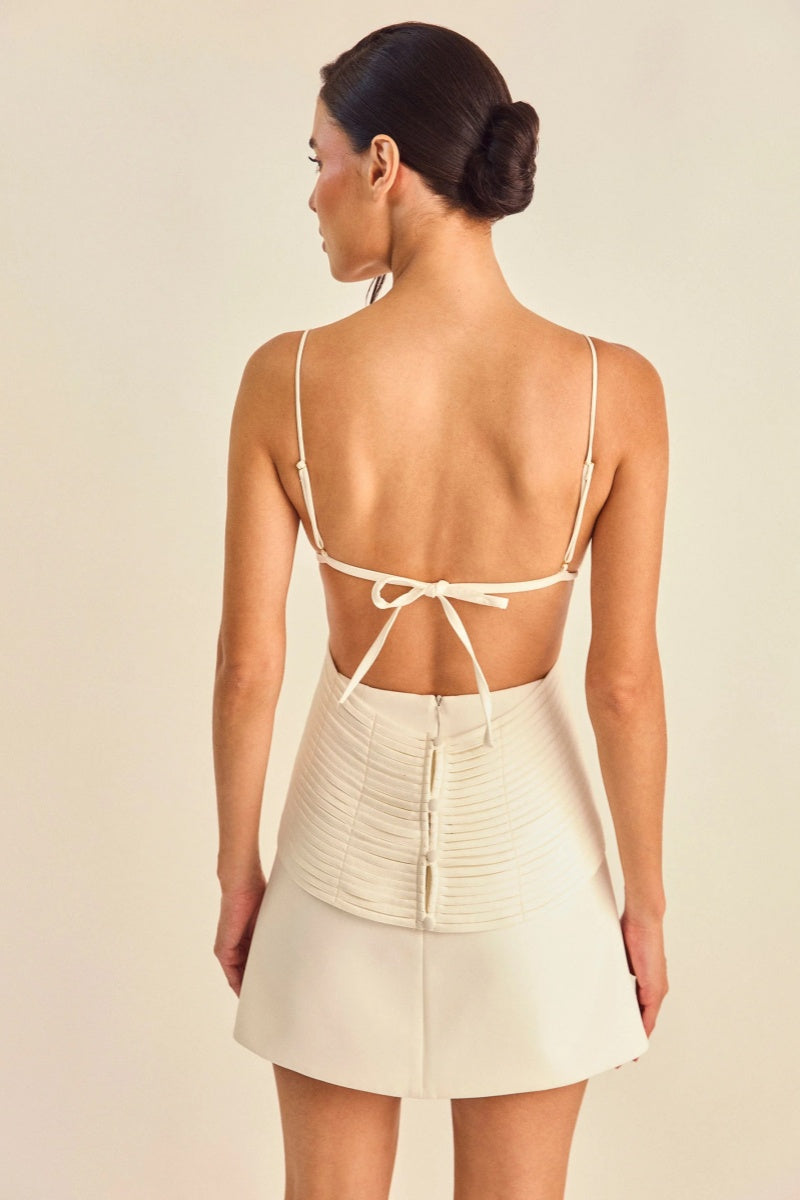 White - Women's cream A-line mini dress featuring a unique criss-cross wrapped bodice with textured banding, a V-neckline, delicate spaghetti straps, and side waist cut-outs.
