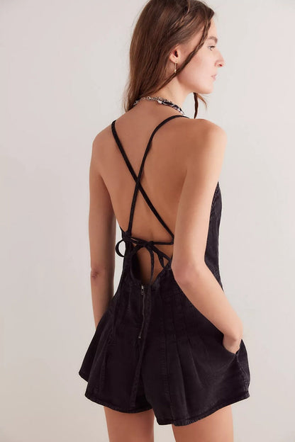 Black - A woman modelling a light blue, structured mini dress featuring a deep plunging V-neckline, panelled bodice seams, and a pleated flared skirt.