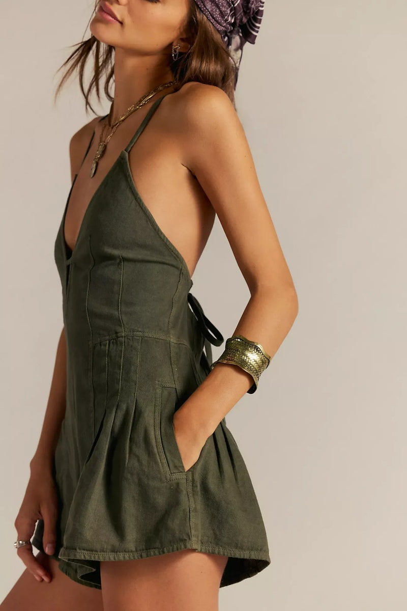 Green - A woman modelling a light blue, structured mini dress featuring a deep plunging V-neckline, panelled bodice seams, and a pleated flared skirt.