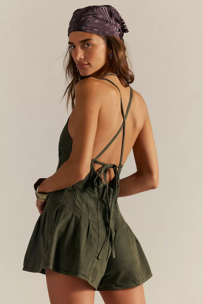 Green - A woman modelling a light blue, structured mini dress featuring a deep plunging V-neckline, panelled bodice seams, and a pleated flared skirt.