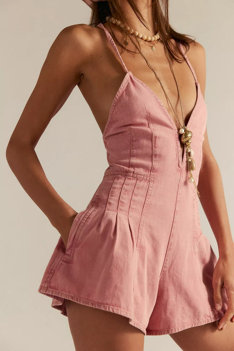 Pink - A woman modelling a light blue, structured mini dress featuring a deep plunging V-neckline, panelled bodice seams, and a pleated flared skirt.