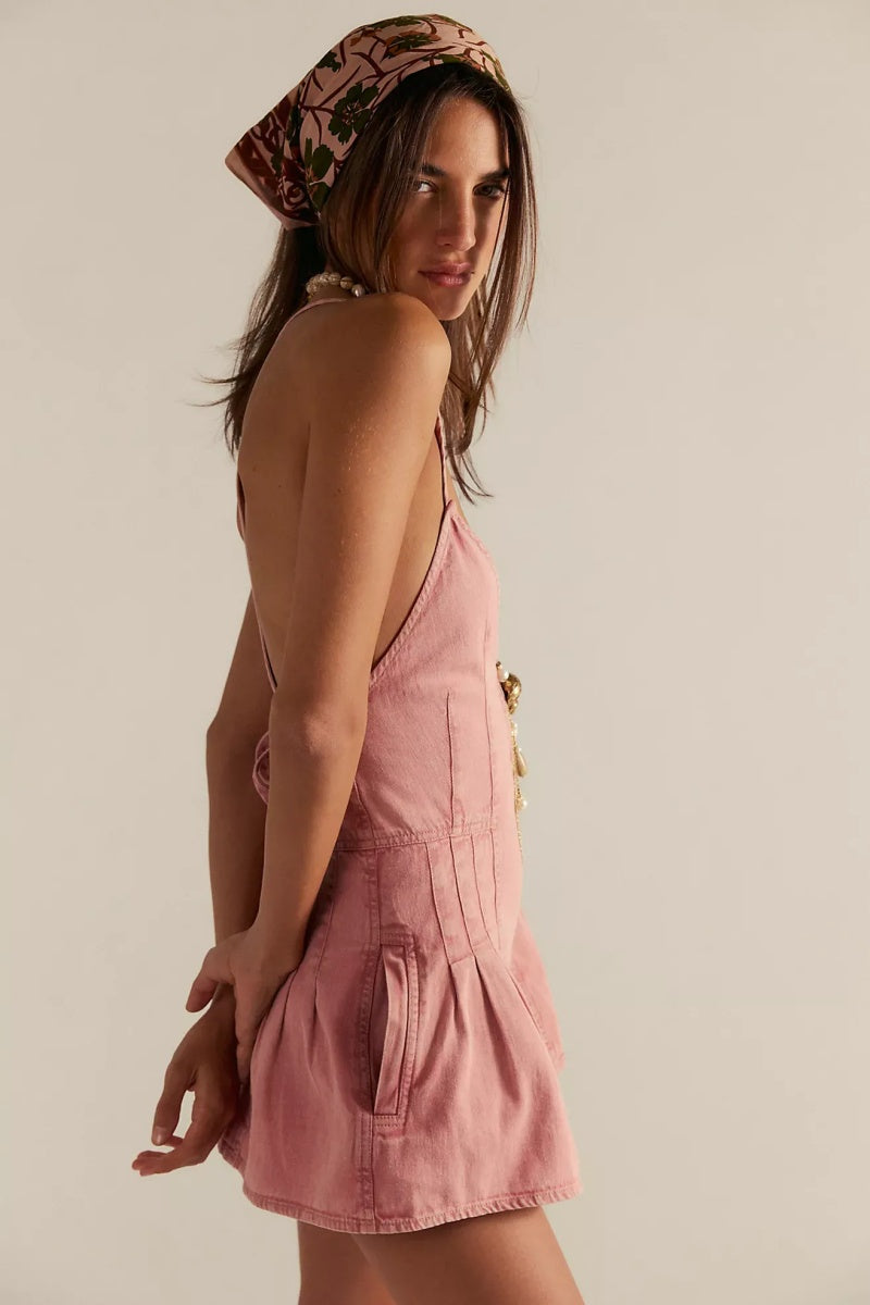 Pink - A woman modelling a light blue, structured mini dress featuring a deep plunging V-neckline, panelled bodice seams, and a pleated flared skirt.