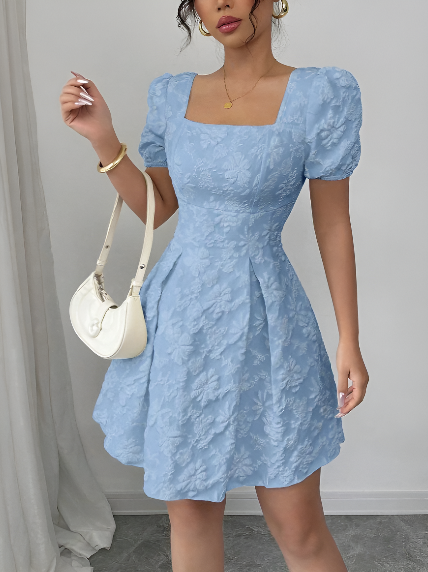 Sky Blue - Model wearing a textured floral jacquard mini dress with a square neckline, short puff sleeves, and a pleated A-line skirt
