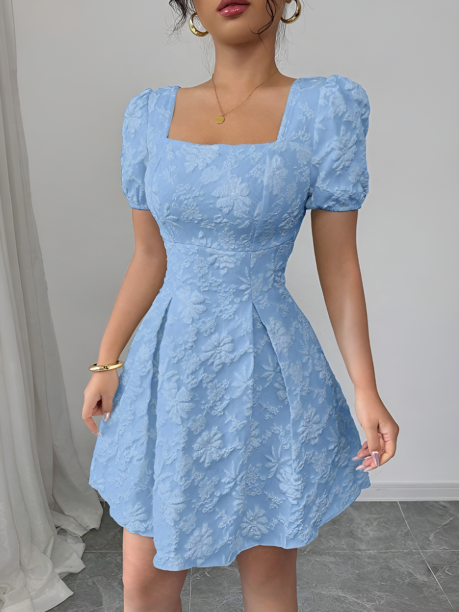 Sky Blue - Model wearing a textured floral jacquard mini dress with a square neckline, short puff sleeves, and a pleated A-line skirt